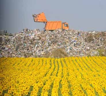 A truck dumps trash in a landfill.